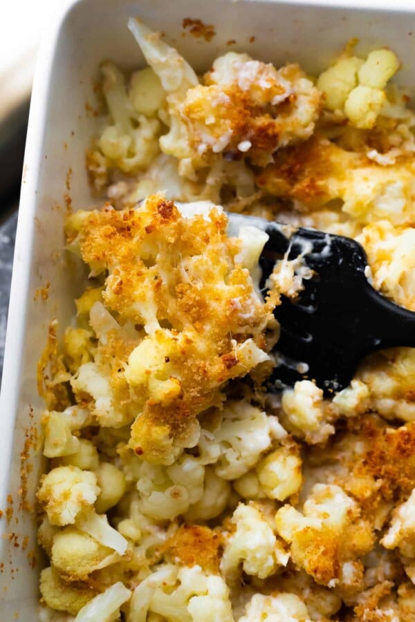 spatula lifting a portion of cauliflower au gratin out of the pan