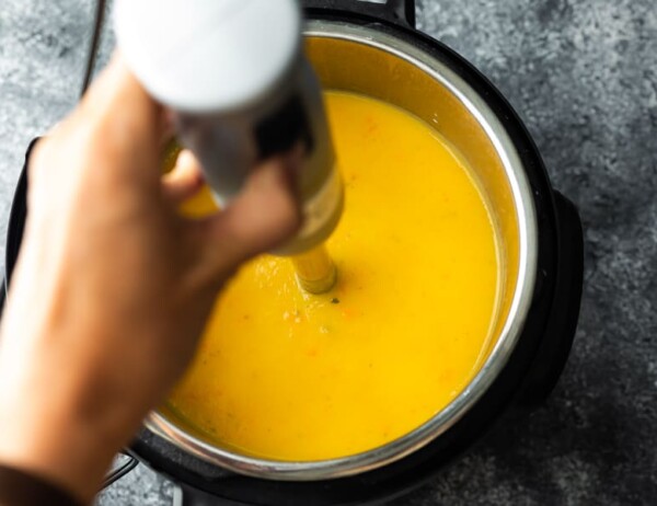blending butternut squash soup in an instant pot with an immersion blender