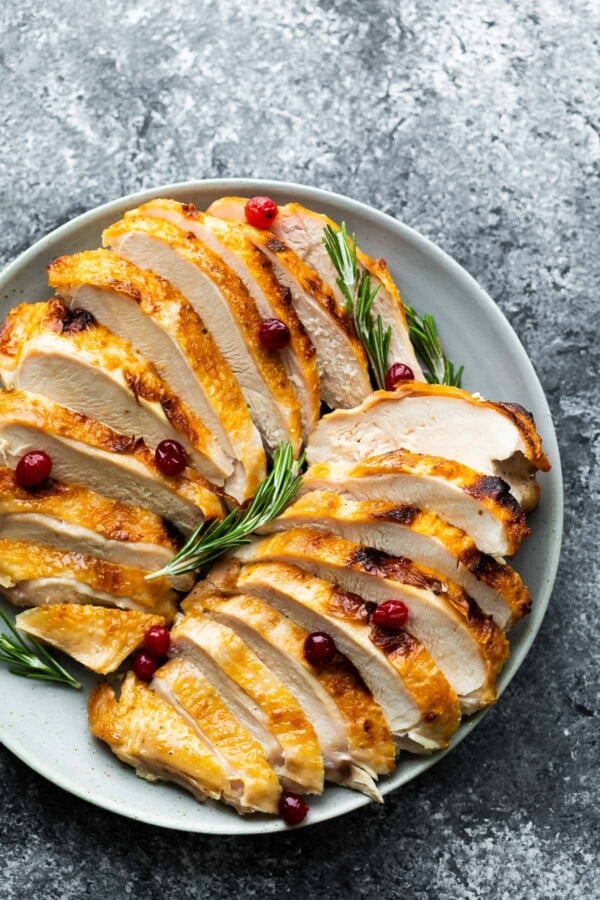 platter with sliced instant pot turkey breast, rosemary and cranberries