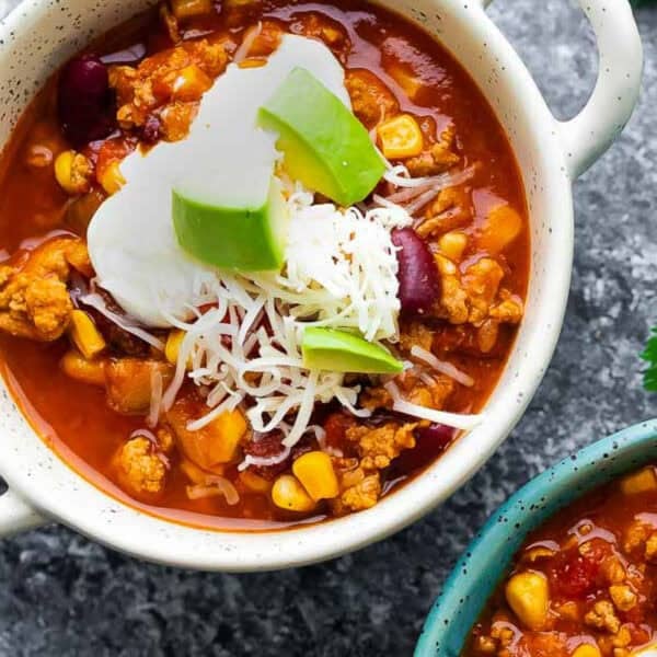 an overhead shot of slow cooker turkey chili in a white bowl with handles