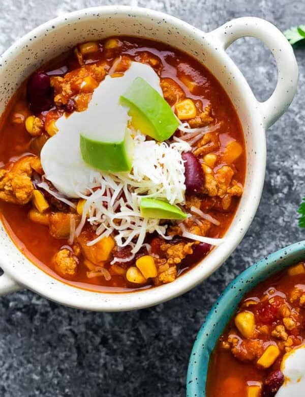 an overhead shot of slow cooker turkey chili in a white bowl with handles