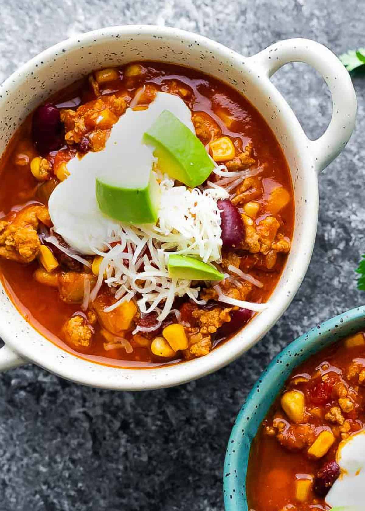 an overhead shot of slow cooker turkey chili in a white bowl with handles