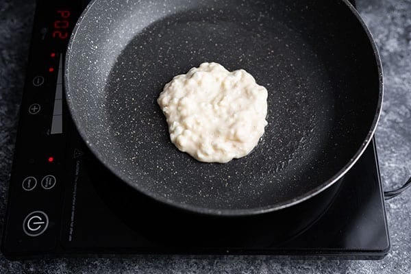 uncooked pancake in frying pan