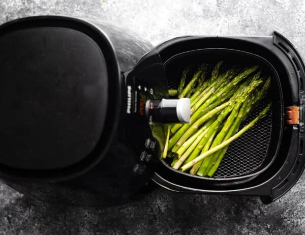 overhead view of asparagus in air fryer with basket pulled out