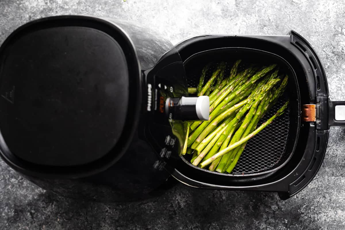 overhead view of asparagus in air fryer with basket pulled out