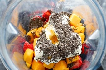 ingredients for strawberry smoothie in blender before blending up