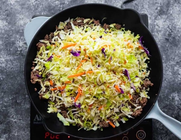 overhead view of egg roll in a bowl in a pan before stirring slaw up