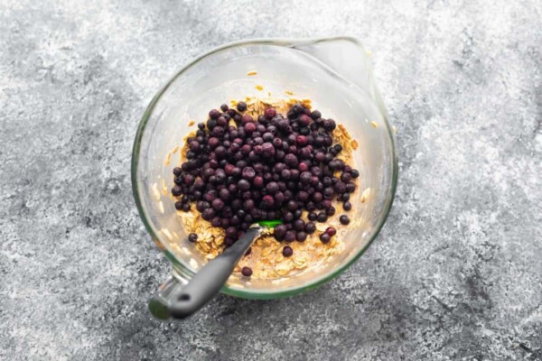 baked oatmeal batter with frozen blueberries on top in a bowl