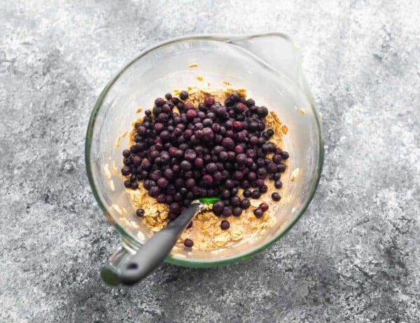 baked oatmeal batter with frozen blueberries on top in a bowl