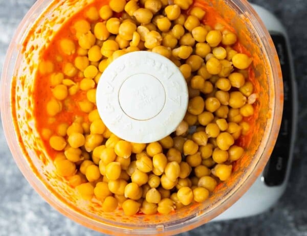 chickpeas added to liquid in food processor to make roasted red pepper hummus