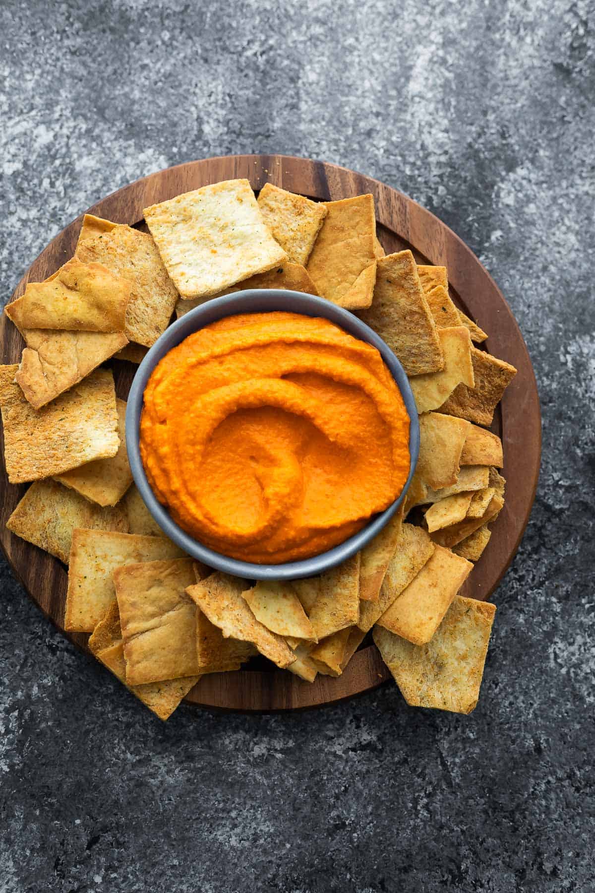 roasted red pepper hummus in a bowl surrounded by pita chips
