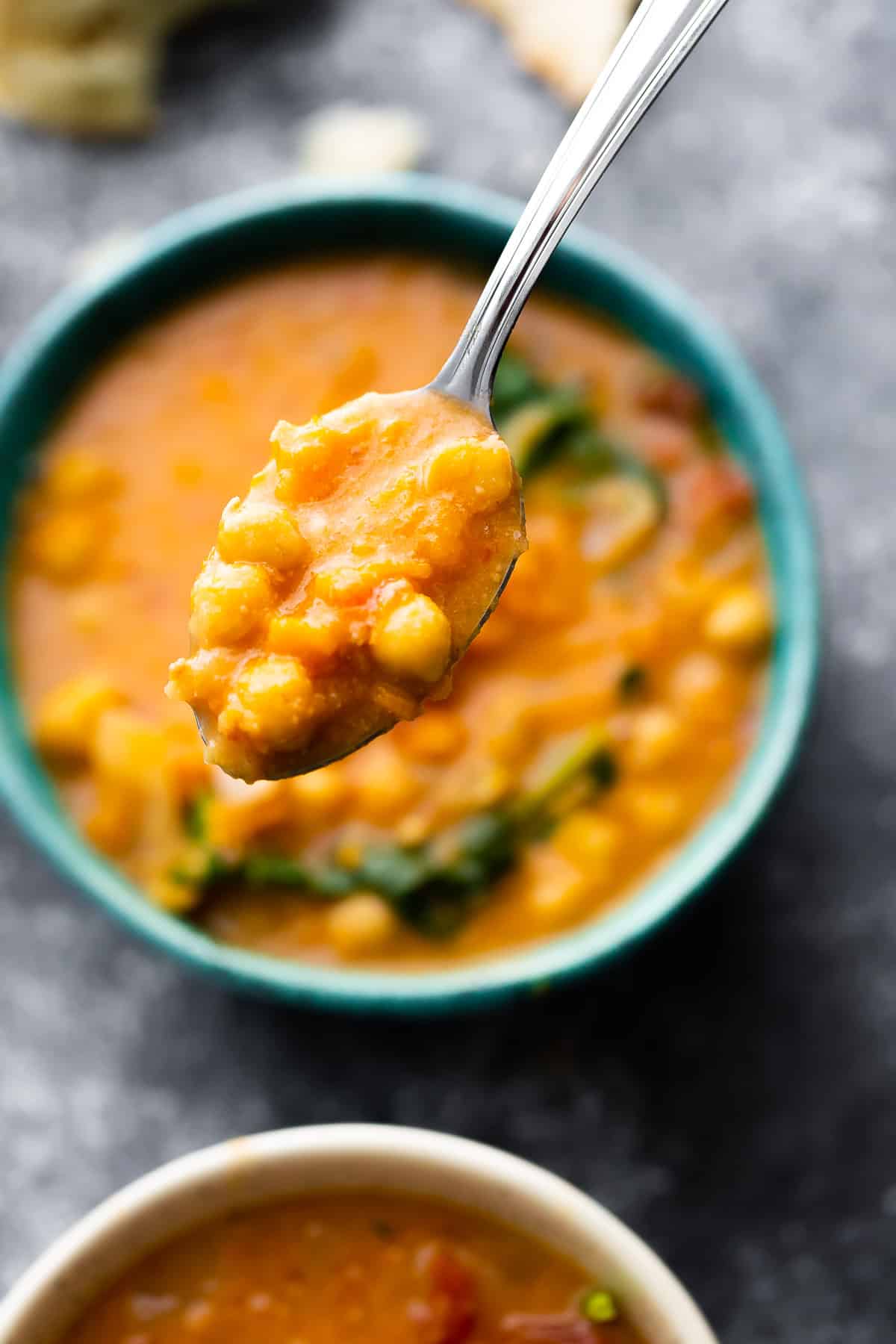 spoonful of peanut stew over blue bowl