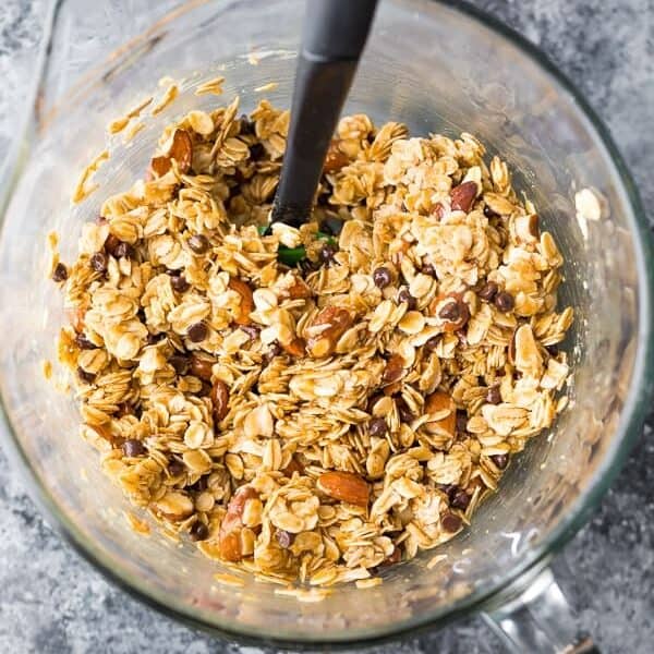 rolled oats, almonds, chocolate chips and granola bar ingredients in large glass mixing bowl from above