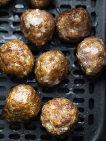 close up shot of meatballs in air fryer basket