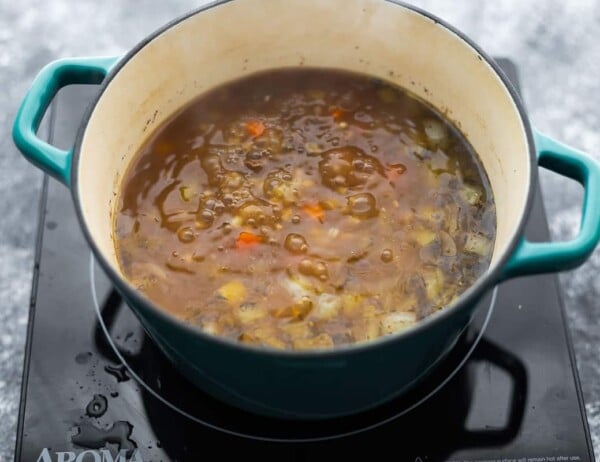 simmering pot of beef barley soup on burner