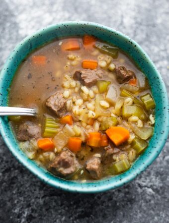 close up shot of beef barley soup with a spoon