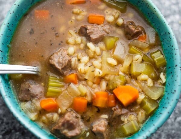 close up shot of beef barley soup with a spoon