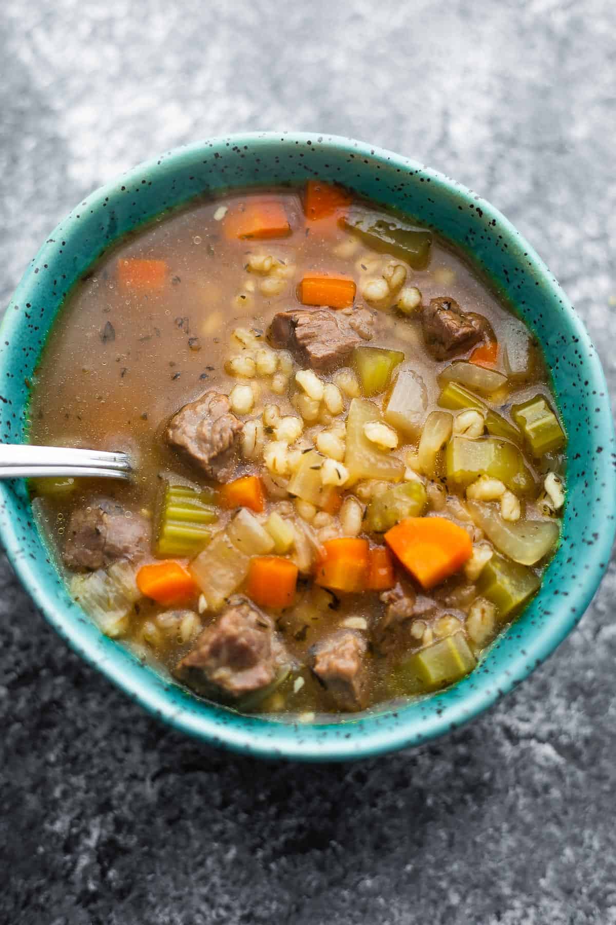 close up shot of beef barley soup with a spoon