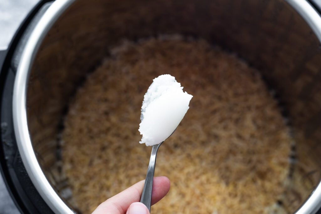 coconut oil on a spoon held over an instant pot