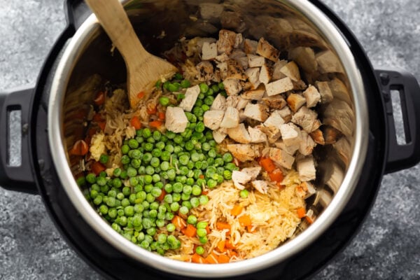 overhead view of fried rice topped with peas and chicken in instant pot