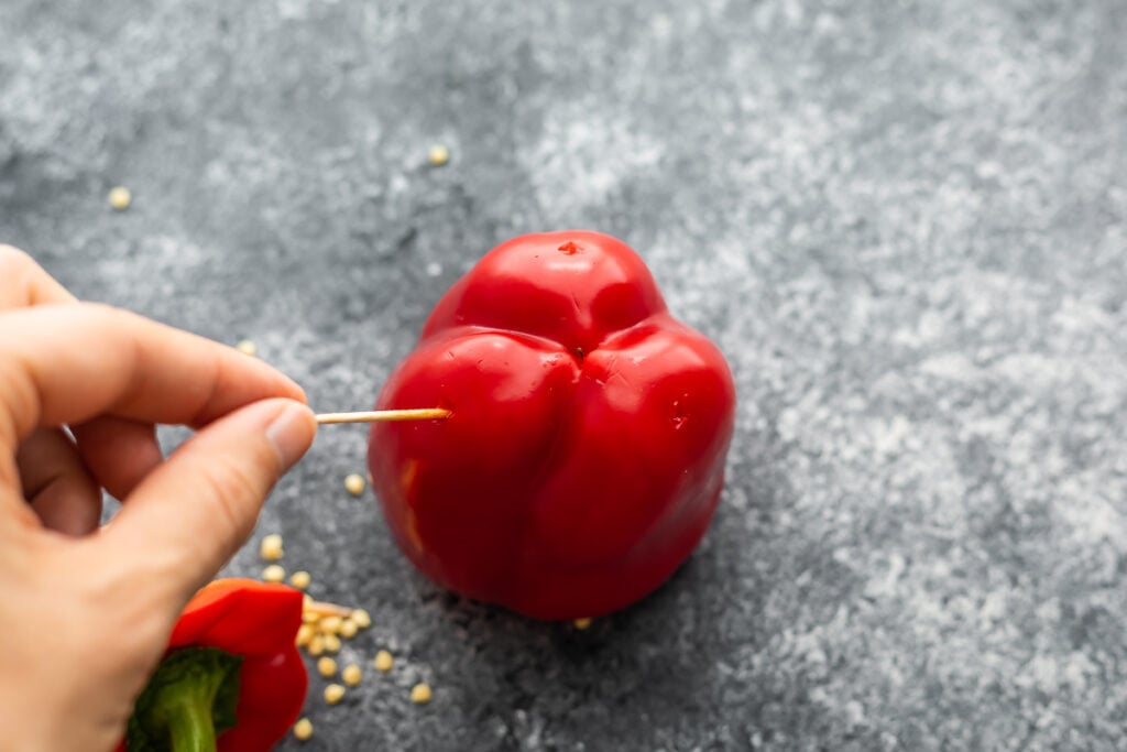 poking a hole in a bell pepper with a toothpick