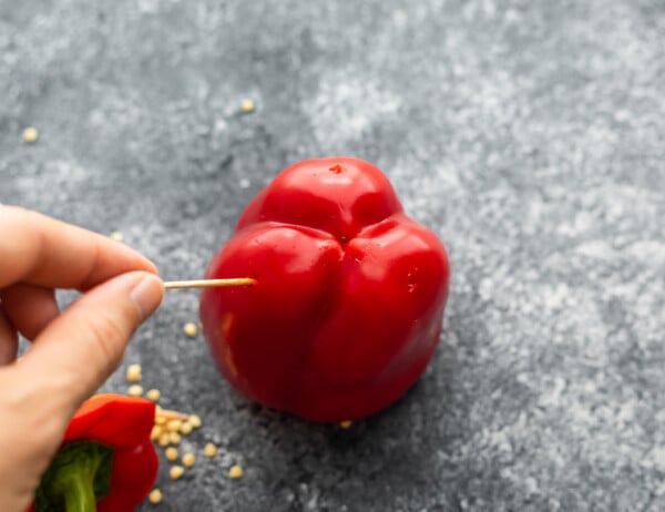 poking a hole in a bell pepper with a toothpick
