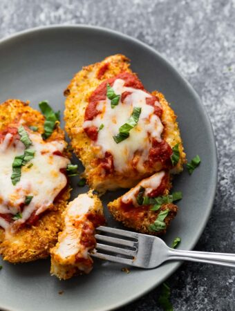 air fryer chicken parmesan on plate, sliced with piece on fork