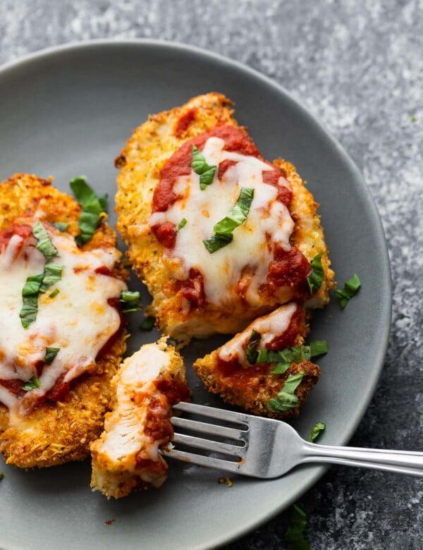 air fryer chicken parmesan on plate, sliced with piece on fork