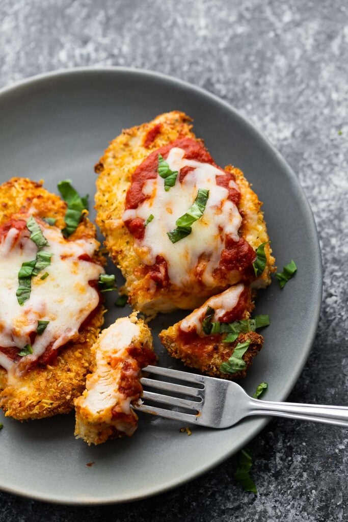 air fryer chicken parmesan on plate, sliced with piece on fork