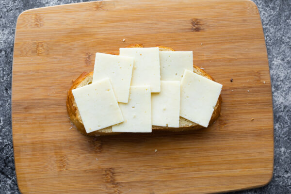 cheese arranged on sourdough bread on cutting board