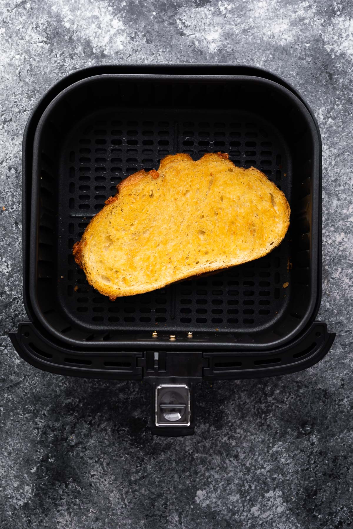 cooked grilled cheese sitting in air fryer basket