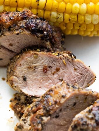 close up shot of sliced pork tenderloin on plate showing the juicy interior