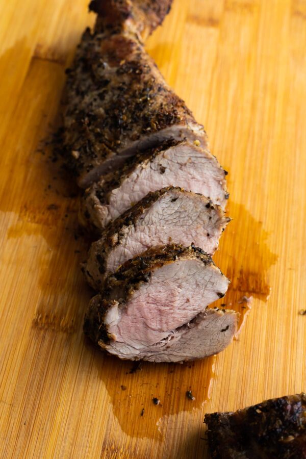side angle view of sliced pork tenderloin on cutting board