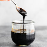 spoon drizzling thick balsamic reduction into a jar