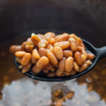 close up shot of pinto beans on large spoon