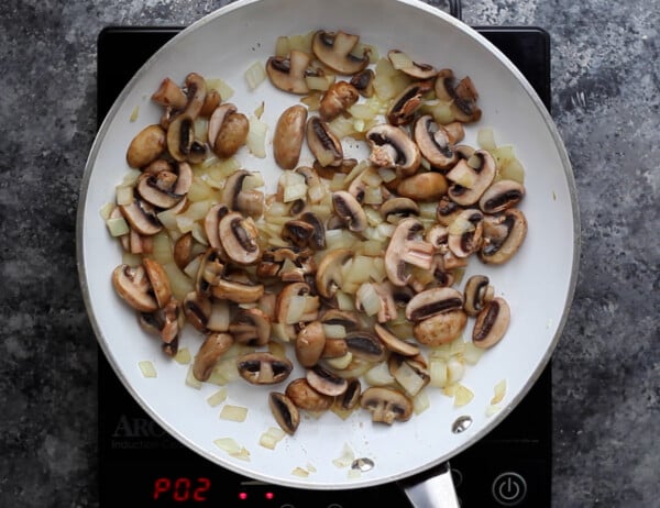 sauteeing mushrooms and onions in pan