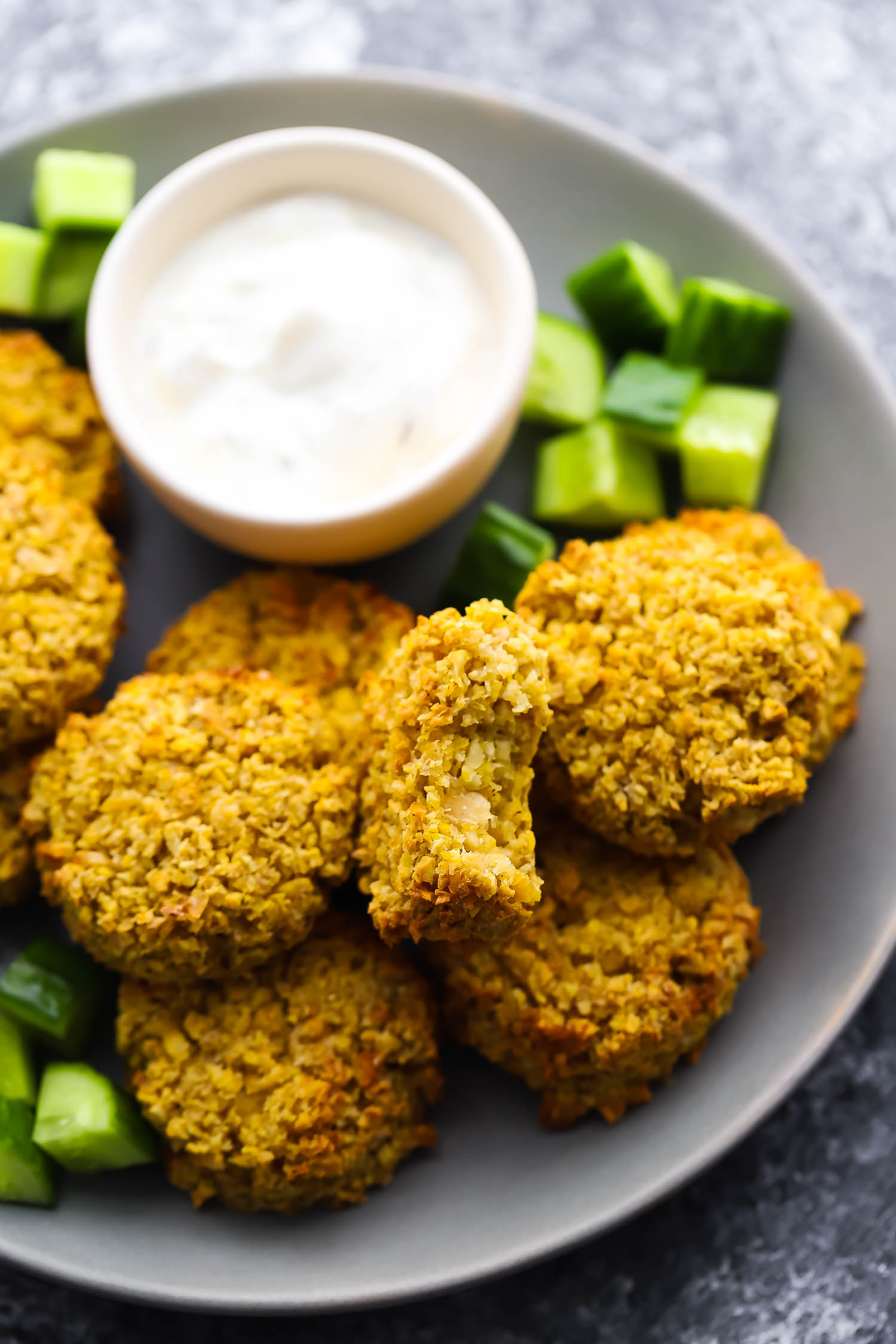 overhead view of falafels on plate, one with a bite taken out of it