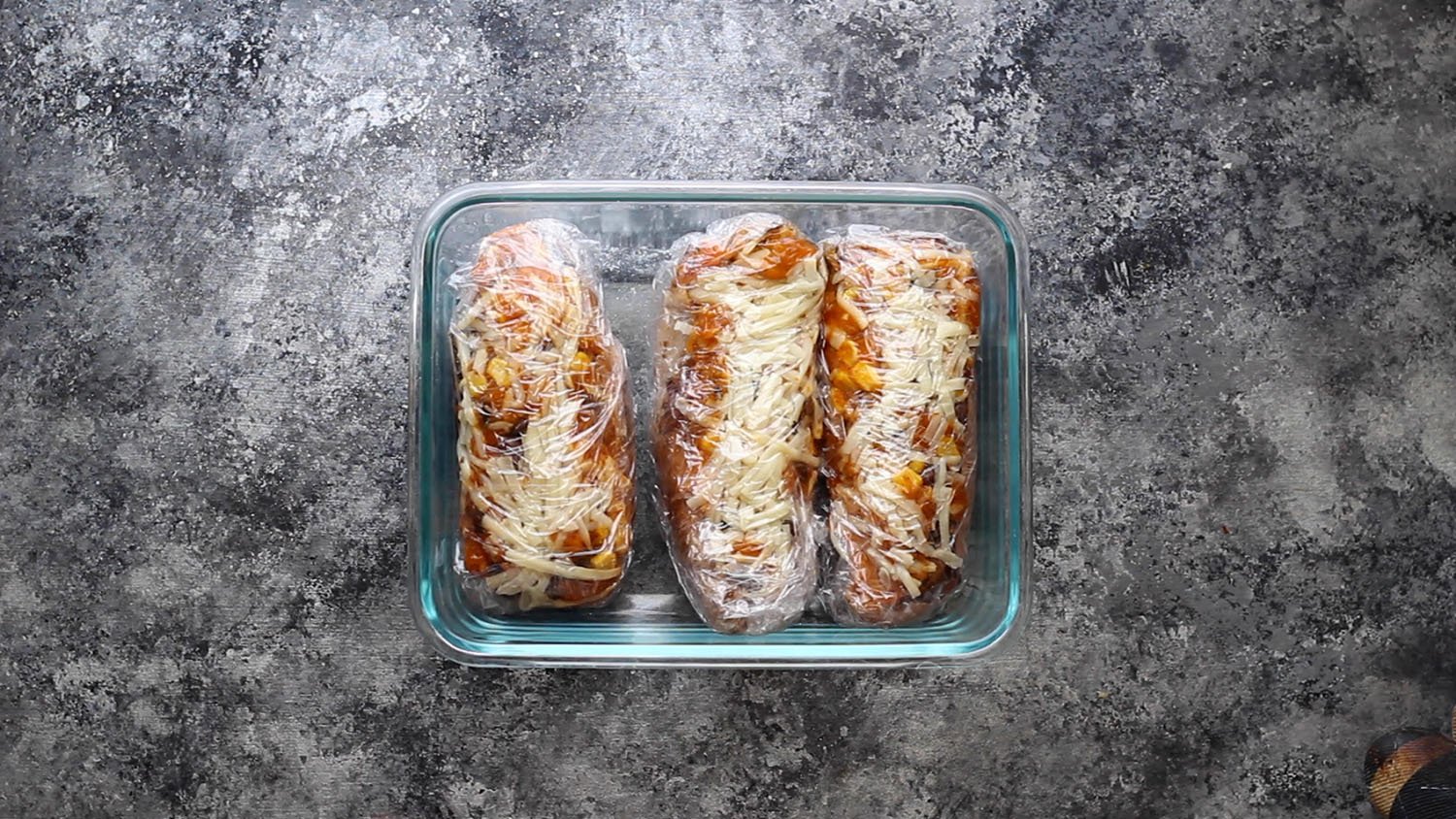 sweet potatoes wrapped in plastic in meal prep container