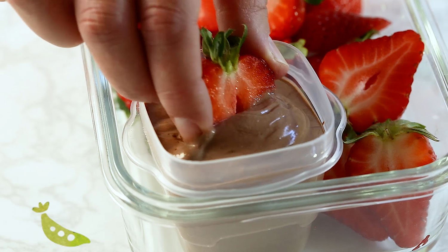 dipping a strawberry into yogurt dip