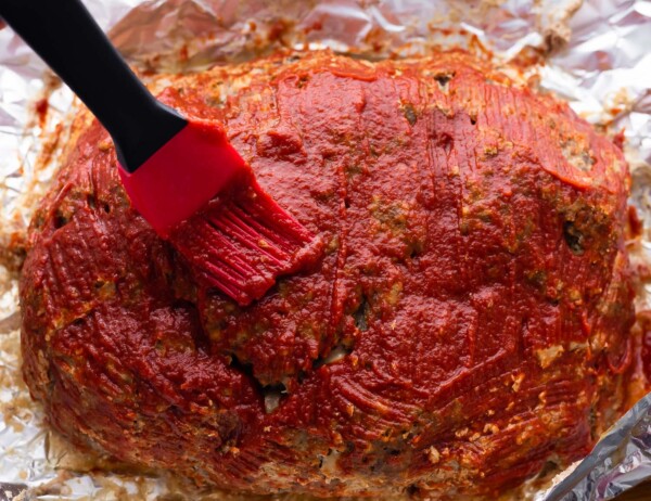 glaze being brushed onto meatloaf