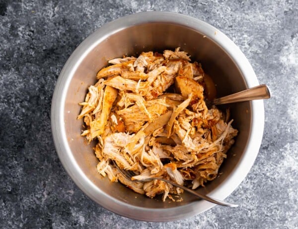 shredded chicken in a bowl with two forks