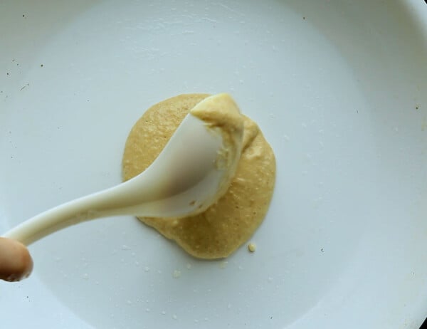 spooning pancake batter into the pan