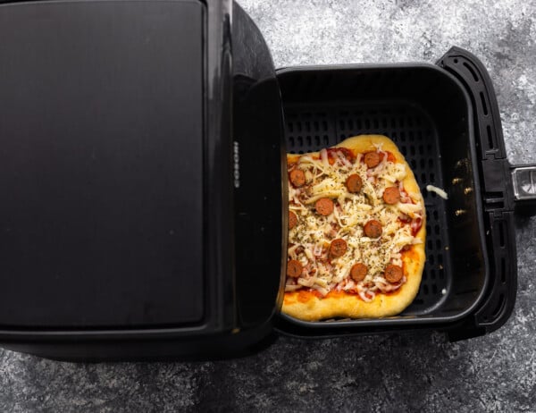 overhead view of uncooked pizza in air fryer