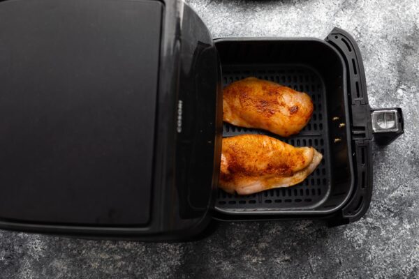 chicken breasts in air fryer basket before cooking
