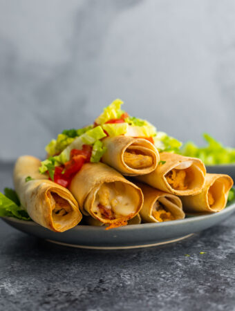 side angle view of plate stacked with taquitos