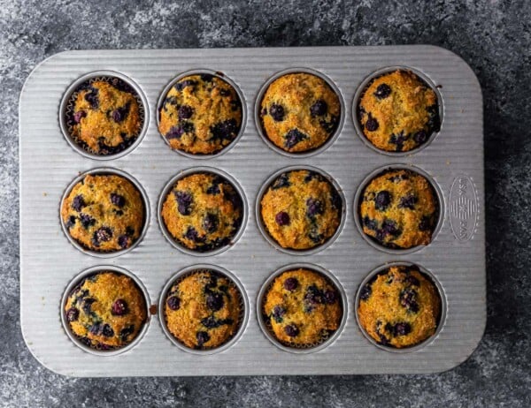 blueberry muffins in muffin pan after baking through- overhead shot