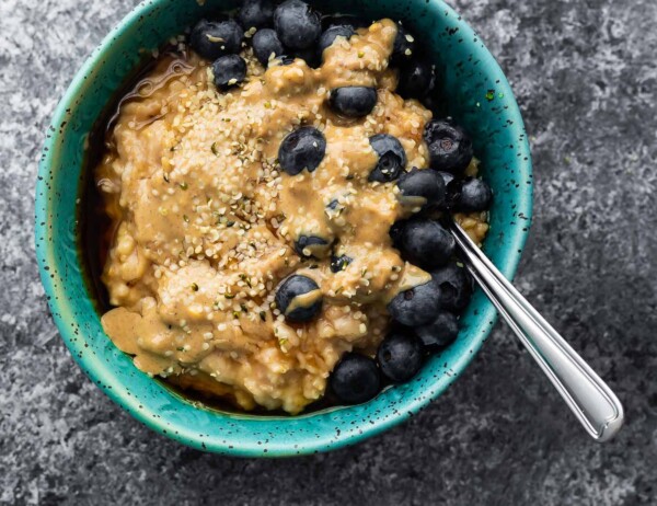 oatmeal in blue bowl with peanut butter and blueberries
