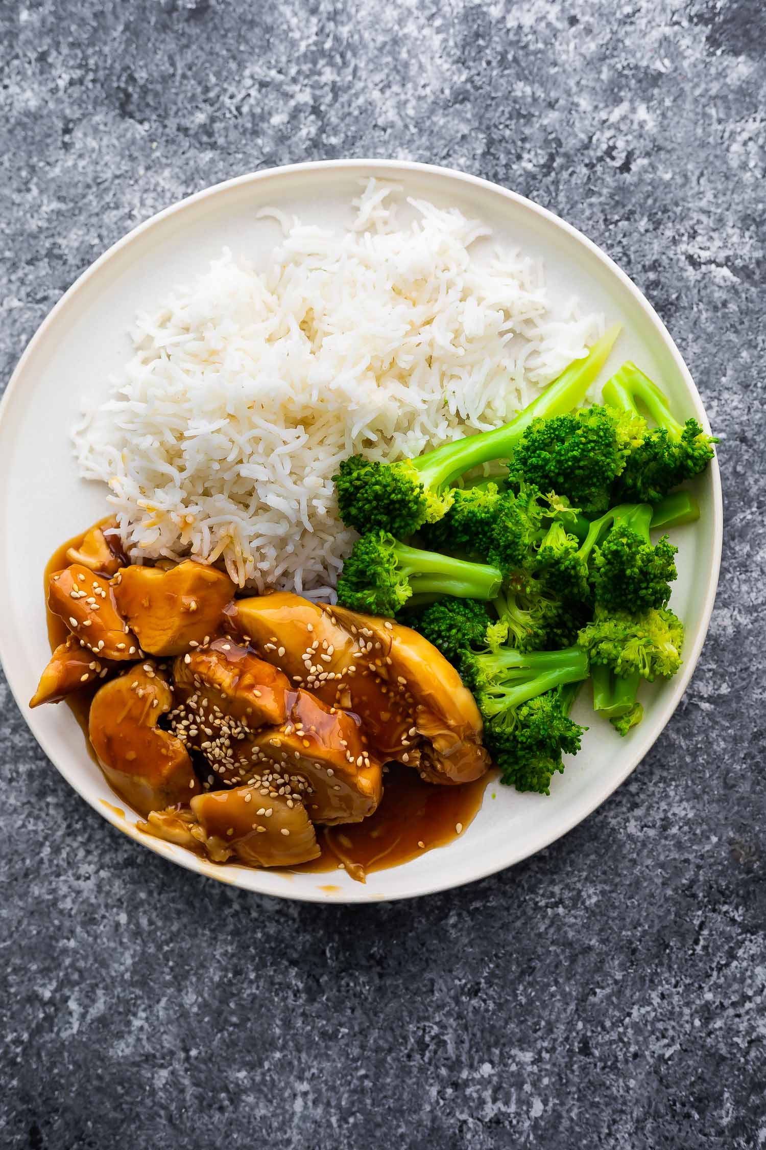 overhead view of teriyaki chicken on plate with rice and broccoli
