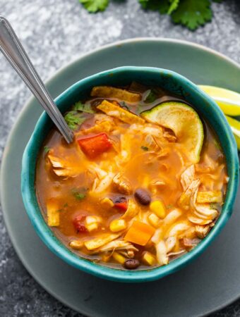 chicken tortilla soup in blue bowl with spoon