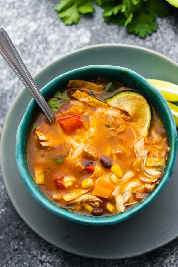 chicken tortilla soup in blue bowl with spoon